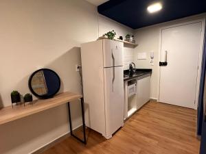 uma cozinha com um frigorífico branco e um balcão em Apê Bela Vista Major em São Paulo