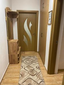 un pasillo con una puerta con una alfombra delante en Апартамент за гости en Devin