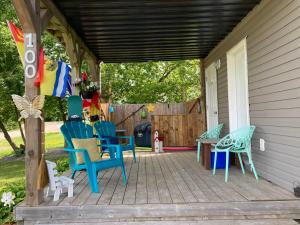 a porch with colorful chairs and a table at Shediac Beachfront in Shediac