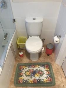 a bathroom with a toilet with a flower rug on the floor at Comfortable room near the shops in Hall