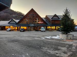 a large lodge with cars parked in a parking lot at Guzet Neige 1400 in Ustou