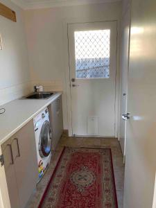 a kitchen with a washing machine and a sink at Comfortable room near the shops in Hall