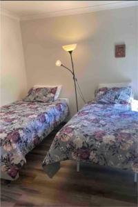 a bedroom with two beds and a lamp in it at Comfortable room near the shops in Hall