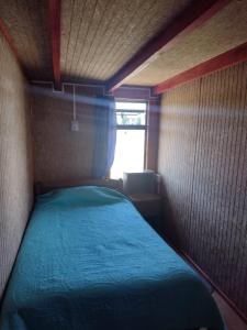 a small bed in a small room with a window at Departamento Rayen Karu in Puerto Montt