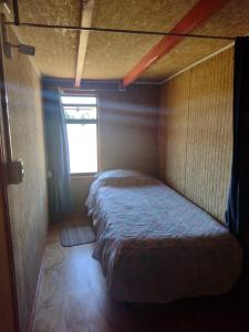 Bett in einem kleinen Zimmer mit Fenster in der Unterkunft Departamento Rayen Karu in Puerto Montt