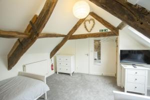 a bedroom with a bed and a ceiling with beams at Castle Cottage in Cardigan