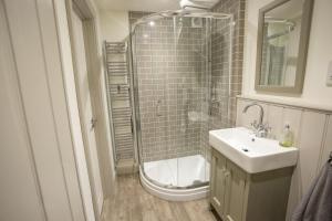 een badkamer met een douche en een wastafel bij Castle Cottage in Cardigan +21 foto's