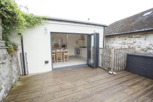 an open door to a patio with a deck at Castle Cottage in Cardigan
