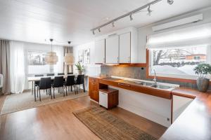 a kitchen with white cabinets and a table with black chairs at Spacious Villa located in Beautiful High Coast in Domsjö