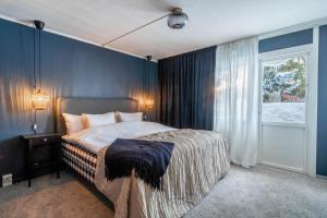 um quarto com uma cama com paredes azuis e uma janela em Spacious Villa located in Beautiful High Coast em Domsjö