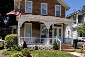 a house with an american flag on the front porch at Rochester Kodak Themed 2 Bedroom Apt With Parking in Rochester