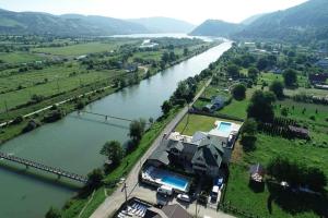 una vista aerea di una casa accanto a un fiume di Pensiunea Lory a Piatra Neamţ
