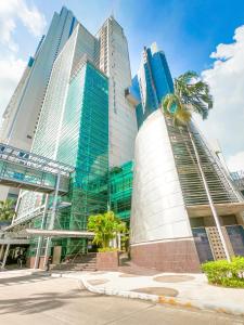 un edificio alto con una palmera delante de él en Decapolis Hotel Panama City en Panamá