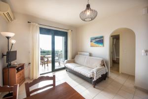 a living room with a couch and a sliding glass door at Portela Apartments Kampoula in Keratokampos