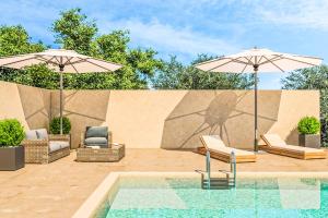 una piscina con 2 sombrillas y 2 sillas y una piscina en Villa Helona, en Marathias