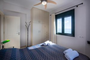 a bedroom with a bed with two towels on it at Portela Apartments Kampoula in Keratokampos