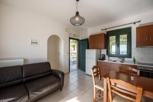ein Wohnzimmer mit einem Sofa und einem Tisch sowie eine Küche in der Unterkunft Portela Apartments Kampoula in Keratókambos