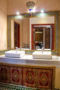 a bathroom with two sinks and a large mirror at Riad Esmeralda in Marrakech