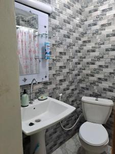 a bathroom with a white toilet and a sink at Casa Djoko in Dakar