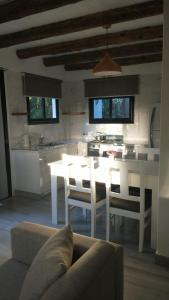cocina con mesa blanca y sillas en una habitación en Cabaña de mar en Quequén