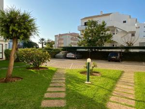 un parc avec un palmier et un parking dans l'établissement Casa de Vilamoura, à Vilamoura