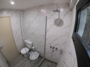 a bathroom with a shower with a toilet and a sink at Cabaña de mar in Quequén