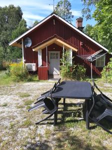 a picnic table in front of a red house at Viken - Cottage by Dalslands Canal in Dals Långed