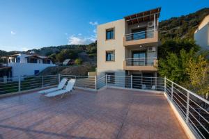 a balcony of a house with a bench at Portela Apartments Kampoula in Keratokampos