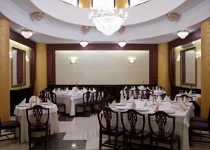 a restaurant with white tables and chairs and a projection screen at Hotel Majestic in Iaşi