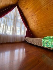 a bedroom with a bed and a large window at Cabaña Villa Makus in Paipa