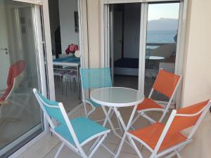 a balcony with a table and chairs and the ocean at Apartment bay, Bougainville Bay Resort in Sarandë