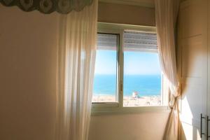 een raam met uitzicht op het strand bij Piano & Sea view Golden Sea (Sunset view & beach) in Ashdod