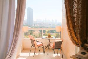 a balcony with a table and chairs and a large window at Piano & Sea view Golden Sea (Sunset view & beach) in Ashdod