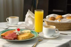 a table with a plate of food and a glass of orange juice at Hotel Real del Sur in Mexico City