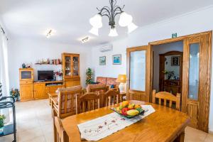 a kitchen and dining room with a table with a bowl of fruit at Villa Tuduri in Binibeca