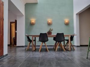 un tavolo in legno con 4 sedie in una stanza di Compass House a Las Palmas de Gran Canaria