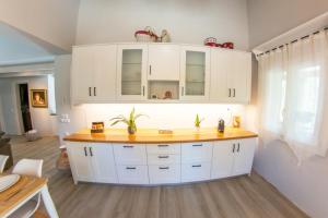 a kitchen with white cabinets and a yellow counter at Corfu Cicada House in Corfu Town