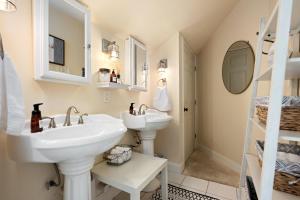 La salle de bains est pourvue de 2 lavabos et d'un miroir. dans l'établissement The Plantation House Boutique Inn, à Pflugerville
