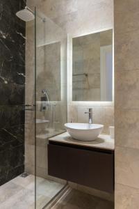 a bathroom with a sink and a glass shower at Voda Luxury Residence #301 in Athens
