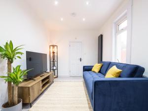 a living room with a blue couch and a tv at Modern 2 bed flat near Wembley Stadium in London
