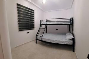- une chambre avec 2 lits superposés dans un mur blanc dans l'établissement Apartamento bajo con terraza y piscina, à Torrevieja