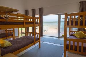 a room with three bunk beds and a window at casa albergue picota in Mazaricos