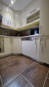 eine Küche mit weißen Schränken und Küchengeräten aus Edelstahl in der Unterkunft Apartments Jelica in Trogir