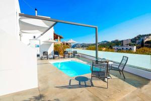 une terrasse avec une piscine, une table et des chaises dans l'établissement Villa Paradiso Ena, à Agia Pelagia