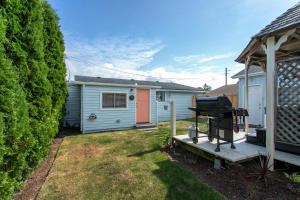 a blue house with a grill in a yard at Cozy 2 Bedroom Home, Private Backyard with Hot Tub in Seaview