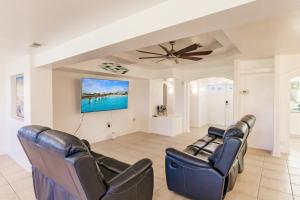 - un salon avec des fauteuils en cuir et un ventilateur de plafond dans l'établissement NEW! Dock Canal Family Home w/Pool & Gulf Access!, à North Fort Myers