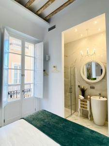 La salle de bains est pourvue d'une baignoire, d'un lavabo et d'un miroir. dans l'établissement inncadizcasa Señorial de Rivadavia, à Cadix