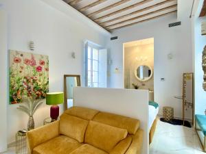 ein Wohnzimmer mit einem Sofa und einem Gemälde in der Unterkunft inncadizcasa Señorial de Rivadavia in Cádiz