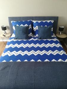 1 cama azul y blanca con 2 almohadas azules en BelMare 424, en Międzyzdroje