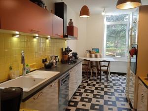 cocina con fregadero y mesa con sillas en Maison calme avec piscine entourée de son parc, en Quintenas